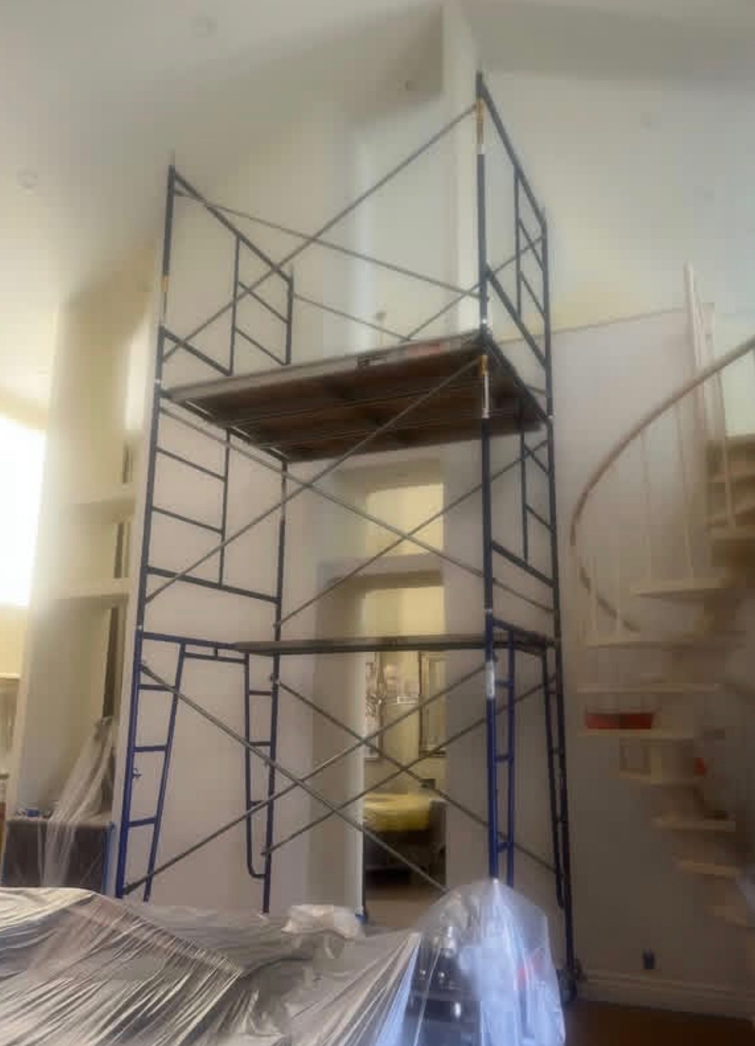 Interior scaffold tower beside a spiral staircase